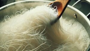 A close-up image of falooda sev being cooked in boiling water.