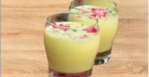 A traditional Indian drink Thandai placed on a plate with milk, nuts, spices, safforon strands and rose petals along with Holi colors