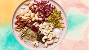 Ingredients for Holi special thandai powder , including milk, almonds, pistachios, saffron, rose petals, and a mix of spices like cardamom and black pepper.